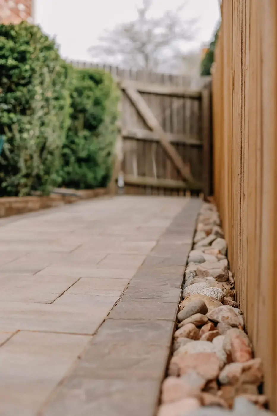 Gray paver walkway running along a side yard
