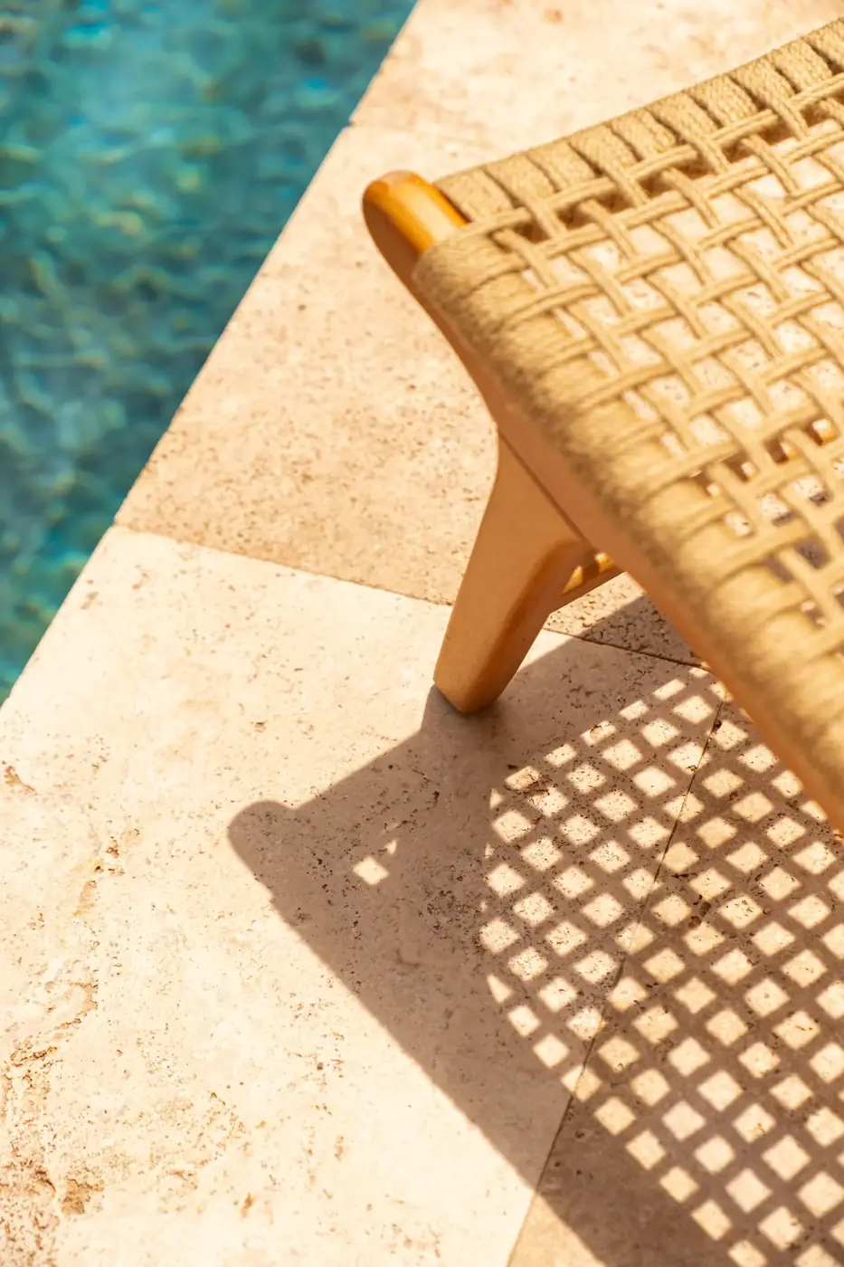 Cream travertine pool coping and deck in bright sun